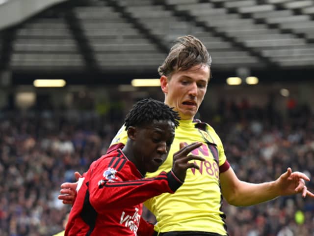 Kobbie Mainoo of Manchester United is challenged by Sander Berge of Burnley