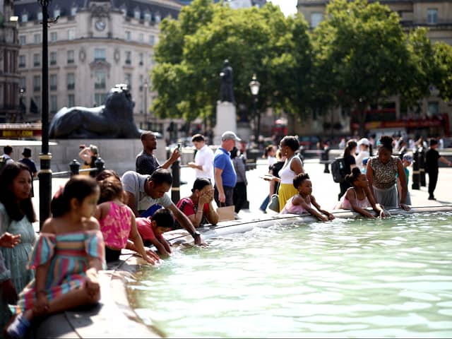 People cool off from the heat at the fountains of Trafalgar square, in central London. (Photo: HENRY NICHOLLS/AFP via Getty Images)