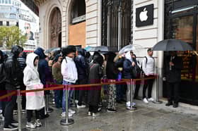 People queue in the rain at an Apple Store in Paris. Photo: MIGUEL MEDINA/AFP via Getty Images