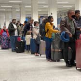 Passengers queue for check in at Manchester Airport's Terminal 1