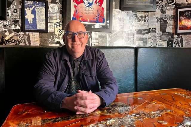 Gavin Sharp, CEO of Band on Wall, sat at a table he made himself from broken saxophone parts.