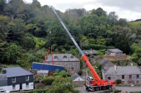 A truck is removed by a crane after getting stuck on a narrow lane in Forder near Saltash, Cornwall.