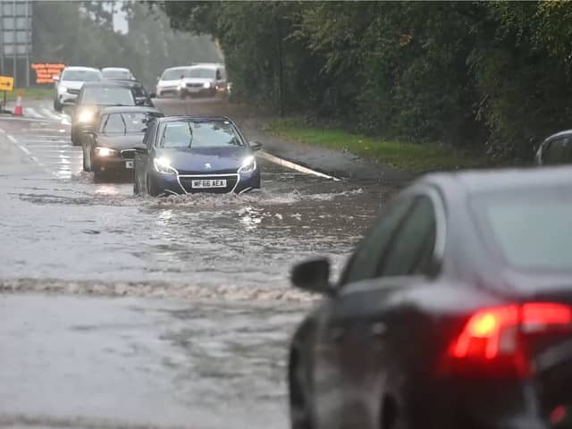 Drivers make their way through flooded roads.