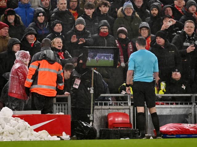 Referee Michael Oliver refers to the on-field VAR screen to review and subsequently award a penalty after Matthijs de Ligt (not pictured) commits handball during the Premier League match between Liverpool FC and Manchester United FC at Anfield on January 05, 2025 in Liverpool, England.