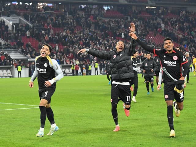 Frankfurt's Egyptian forward #07 Omar Marmoush (L), Frankfurt's French forward #11 Hugo Ekitike (C) and Frankfurt's German forward #36 Ansgar Knauff (R) celebrate with the fans after winning the German first division Bundesliga football match VfB Stuttgart vs Eintracht Frankfurt. (Photo by THOMAS KIENZLE/AFP via Getty Images)