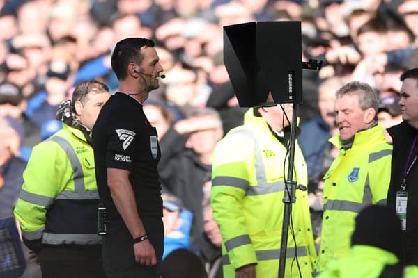 Match Referee, Andrew Madley is pictured consulting the Video Assistant Referee (VAR) to determine a penalty during the Premier League match between Everton FC and Manchester United FC at Goodison Park on February 22, 2025 in Liverpool, England