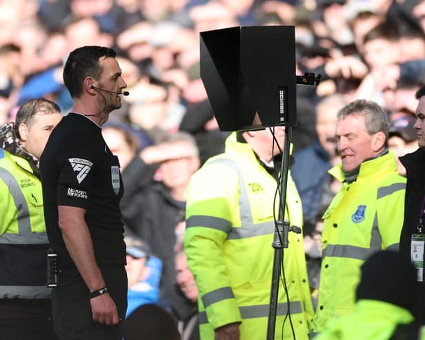 Match Referee, Andrew Madley is pictured consulting the Video Assistant Referee (VAR) to determine a penalty during the Premier League match between Everton FC and Manchester United FC at Goodison Park on February 22, 2025 in Liverpool, England