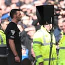 Match Referee, Andrew Madley is pictured consulting the Video Assistant Referee (VAR) to determine a penalty during the Premier League match between Everton FC and Manchester United FC at Goodison Park on February 22, 2025 in Liverpool, England