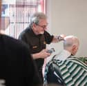 Graham Evans cutting the hair of his regular customer John