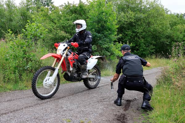 Officer applying a Smart Tag to motorbike and rider