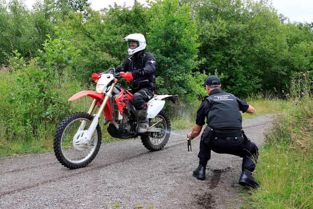 Officer applying a Smart Tag to motorbike and rider