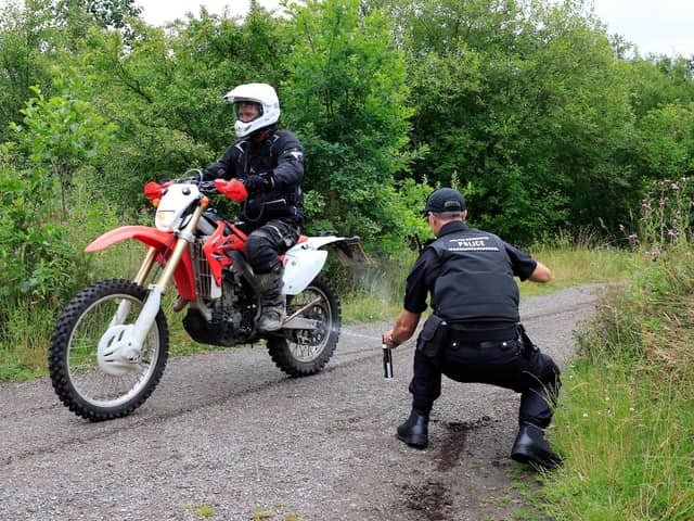 Officer applying a Smart Tag to motorbike and rider