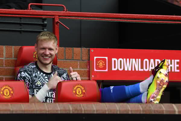 Aaron Ramsdale of Arsenal gestures a thumbs up as he poses for a photograph whilst sitting on the bench prior to the Premier League match between Manchester United and Arsenal FC at Old Trafford on May 12, 2024 in Manchester, England.
