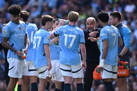 Pep Guardiola, Manager of Manchester City speaks with Kevin De Bruyne of Manchester City and  of Manchester City  during the Premier League match between Manchester City FC and Crystal Palace FC at Etihad Stadium on April 12, 2025 in Manchester, England. 