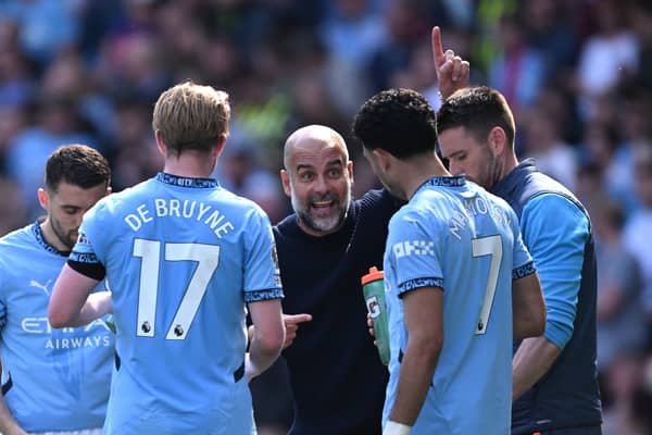 Pep Guardiola, Manager of Manchester City speaks with Kevin De Bruyne of Manchester City and  of Manchester City  during the Premier League match between Manchester City FC and Crystal Palace FC at Etihad Stadium on April 12, 2025 in Manchester, England. 