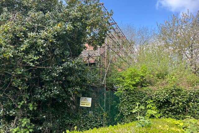 The Watling Gate building can now hardly be seen because of the overgrown trees and shrubbery in its grounds