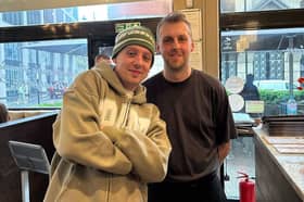 Manchester rapper Aitch poses with a Moose Coffee employee inside the chain's York Street branch,