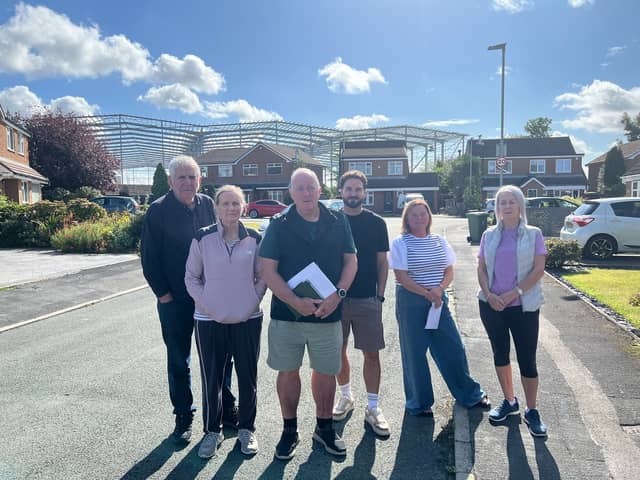 Tyldesley residents from left John and Jackie Peters, Steve Retford, Craig Davies, Jo Gerrard and Hazel White with the warehousing structures in the background