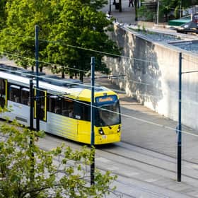 Tram services on the Ashton Metrolink line have been suspended after a vehicle became stuck on the tracks