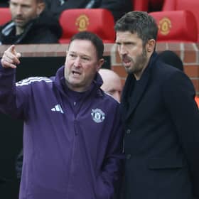 Manchester United's assistant coach Steve Holland (L) and Manchester United's English Interim head coach Michael Carrick (R) speak during the English Premier League football match between Manchester United and Manchester City at Old Trafford in Manchester, north west England, on January 17, 2026. 