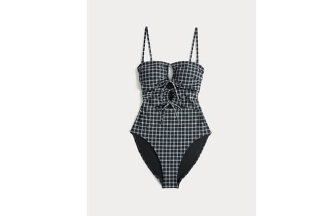The M&S Checked Cut Out Bandeau Swimsuit combines a modern cut-out design with a flattering bandeau silhouette