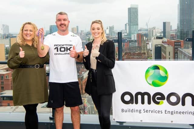 Ameon's Steve McCourt ends the world's first rooftop 10K in aid of the NHS, with a medal from co-organisers, Vox Manchester's Kate Howell, left, and Indea Garlick