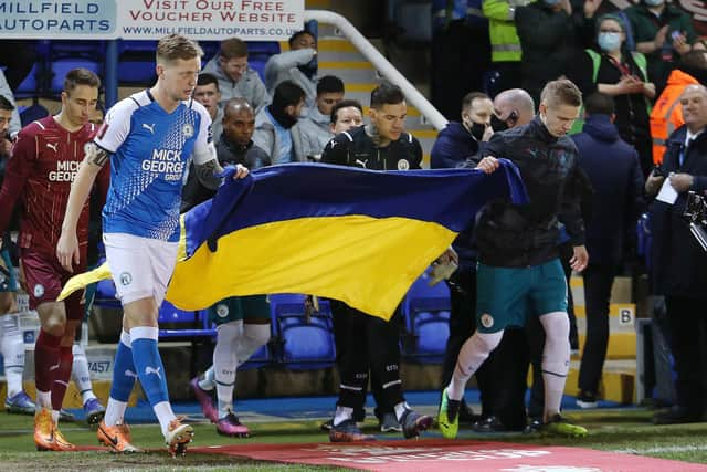 Posh captain Frankie Kent and Manchester City's Oleksandr Zinchenko show support to Ukraine before the game.