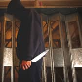 PICTURE POSED BY MODEL. A general view of a man in a hoodie holding a knife.