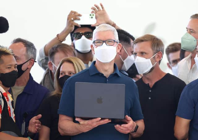 <p>Apple chief executive Tim Cook (centre) holds a newly redesigned MacBook Air laptop. Picture: Justin Sullivan/Getty Images</p>
