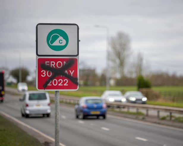 A defaced Greater Manchester Clean Air-Zone warning side