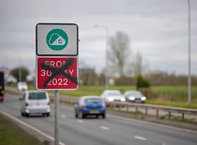 A defaced Greater Manchester Clean Air-Zone warning side, with the old start date amended 