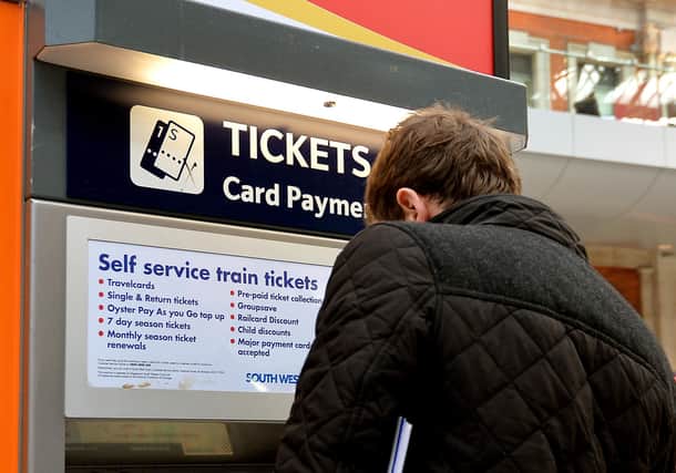 File photo dated 08/12/14 of a train passenger buying a ticket at Waterloo Station in central London, as several train companies are suffering problems accepting card payments for tickets.