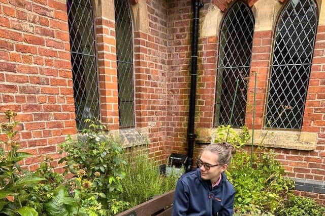 Oliver Hulme, grandson of Norma Copeland, with the memorial bench in her memory.