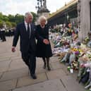 King Charles III and Camilla, Queen Consort view tributes left outside Buckingham Palace, London yesterday  Picture: Yui Mok - WPA Pool/Getty Images