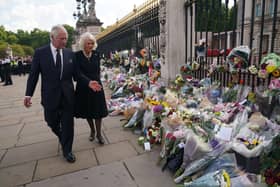King Charles III and Camilla, Queen Consort view tributes left outside Buckingham Palace, London yesterday  Picture: Yui Mok - WPA Pool/Getty Images