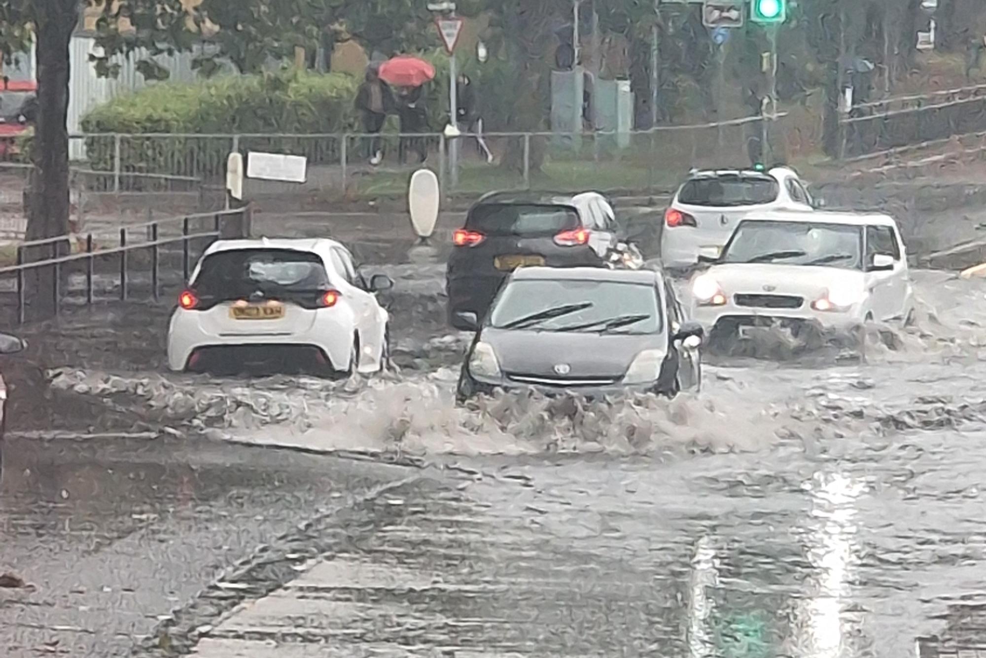 Watch scenes across the UK as cars left under water and schools closed amid amber weather and flood alerts