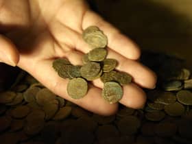 Part of a Roman coin hoard found in Snodland in north Kent is looked at closely by a British Museum worker; the coin hoard, discovered by a digger driver, is made up of over 3,600 coins and is part of the British Museum's annual report of treasure finds at the British Museum in London.