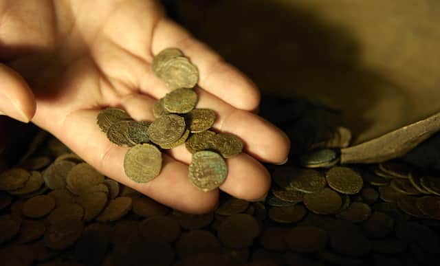 Part of a Roman coin hoard found in Snodland in north Kent is looked at closely by a British Museum worker; the coin hoard, discovered by a digger driver, is made up of over 3,600 coins and is part of the British Museum's annual report of treasure finds at the British Museum in London.