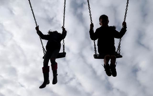 PERMISSION GRANTED. Children enjoy playing on swings in a park near Ashford, Kent.
