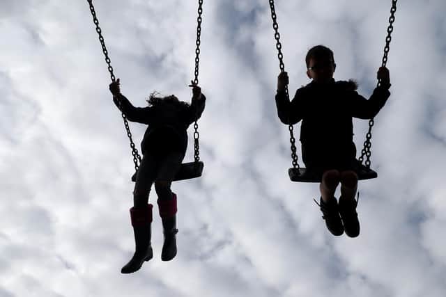 PERMISSION GRANTED. Children enjoy playing on swings in a park near Ashford, Kent.