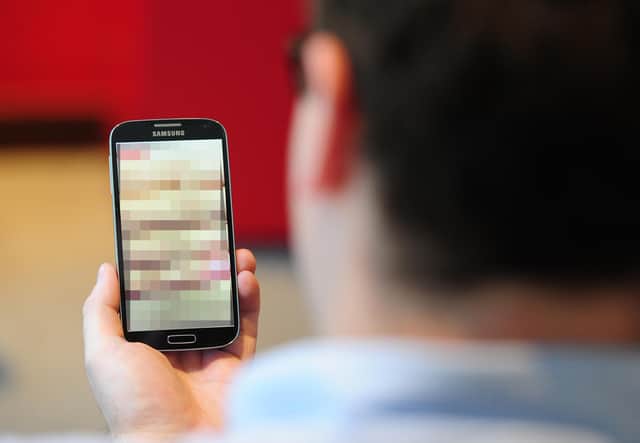 PICTURE POSED BY MODEL
Undated photo of a man looking at a mobile phone. Clarification is needed on the law around "revenge porn" and when it could lead to a prosecution, a committee of peers has said.
