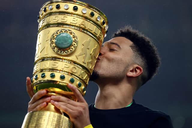 BERLIN, GERMANY - MAY 13: Jadon Sancho of Borussia Dortmund celebrates with the trophy after winning the DFB Cup final match between RB Leipzig and Borussia Dortmund at Olympic Stadium on May 13, 2021 in Berlin, Germany. (Photo by Martin Rose/Getty Images)