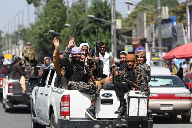 Taliban fighters wave as they patrol in a convoy along a street in Kabul. Picture: Aamir Qureshi/AFP via Getty Images