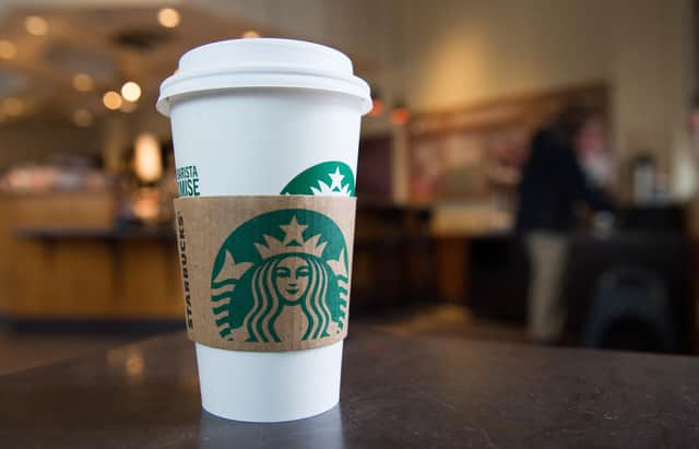 A Starbucks coffee cup is seen inside a Starbucks Coffee shop (Photo by SAUL LOEB/AFP via Getty Images)