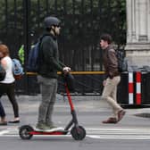 A person riding an electric scooter in Westminster, London.
