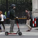 A person riding an electric scooter in Westminster, London.
