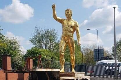 The naked golden statue stood on the back of a truck, ready for removal from Grant's Bulldog Forge.