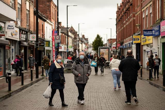 Shoppers, wearing facemasks because of the novel coronavirus pandemic, walk in the High Street of Leigh, Greater Manchester, northwest England on October 22, 2020, as new restrictions meant to contain surging cases of Covid-19 are imposed on Greater Manchester. - Britain's Prime Minister Boris Johnson's government unilaterally imposed the rules on Greater Manchester after failing to reach a funding deal with its mayor Andy Burnham, a former Labour MP for Leigh. But locals say widespread confusion and fatigue with Britain's Covid-19 response risk undermining the government's latest plans. (Photo by OLI SCARFF / AFP) / To go with AFP story by James PHEBY (Photo by OLI SCARFF/AFP via Getty Images)