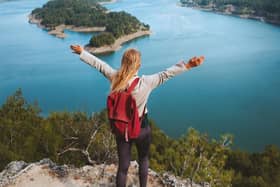 Woman hiker raised hands enjoying Karacaoren lake view travel outdoor in Turkey.