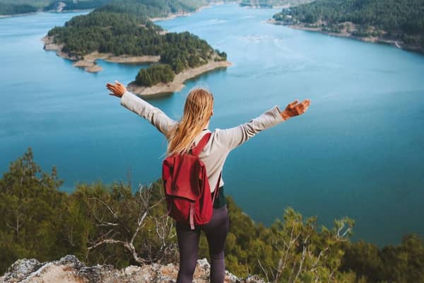 Woman hiker raised hands enjoying Karacaoren lake view travel outdoor in Turkey.